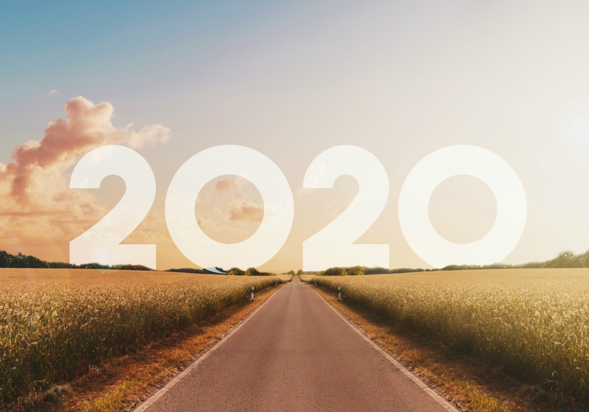 A road through fields toward the horizon, with 2020 written across the sky